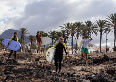 beginner group entering surf spot for the surfing lesson in Playa de Las Americas