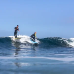 Surfers practicing their skills during a surf lesson in the waters of Tenerife.