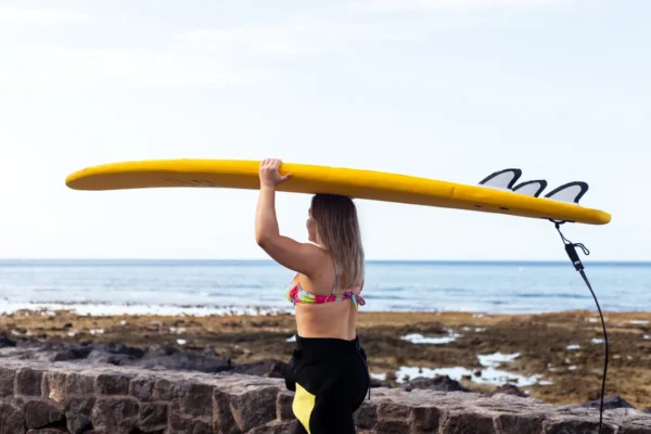 surfer walking for a surfing lesson with Rocky Point Surf School