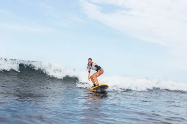 Surfer riding a wave on a softboard at Rocky Point Surf School, Tenerife.